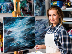 Alumna showcases her beautiful artwork on an easel